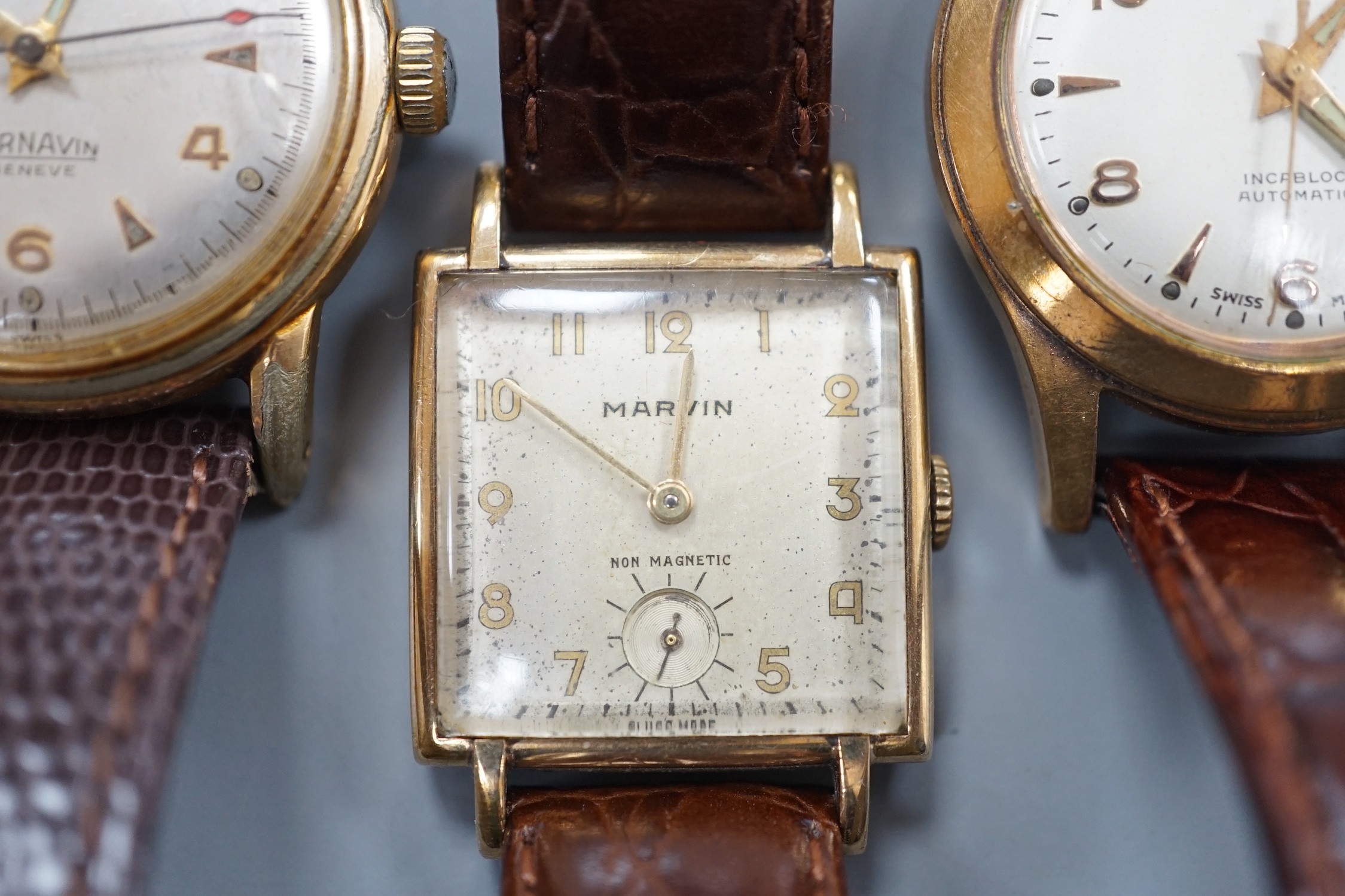 A gentleman's 1940's 9ct gold Marvin square dial manual wind wrist watch, on a later leather strap, together with two other gentleman's steel and gold plated wrist watches, Cornavin and Curtiss automatic.